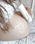 Pregnant woman applying Pod Organics Magnesium Body Rub to sore muscles