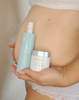 Mum-to-be massaging belly oil into her bump for hydration and stretch mark care